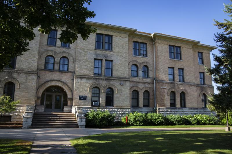 three-story brownstone building with a concrete path leading up to its short stone steps