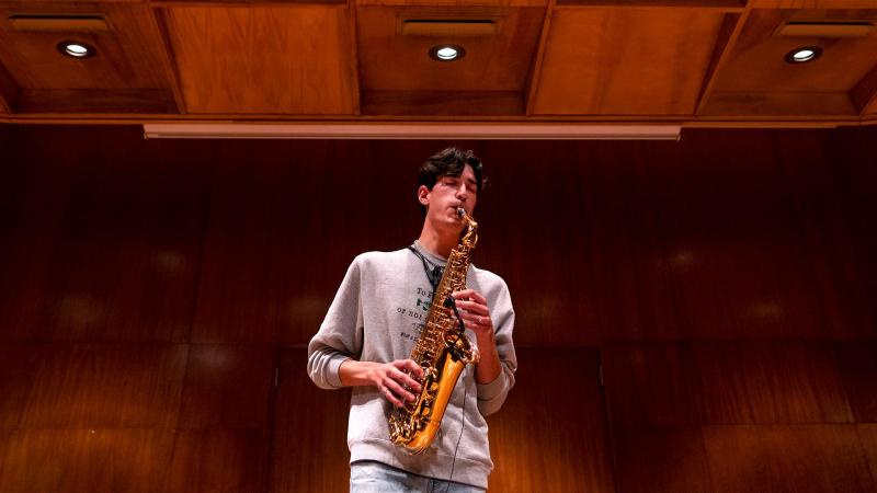 Student plays saxophone on stage