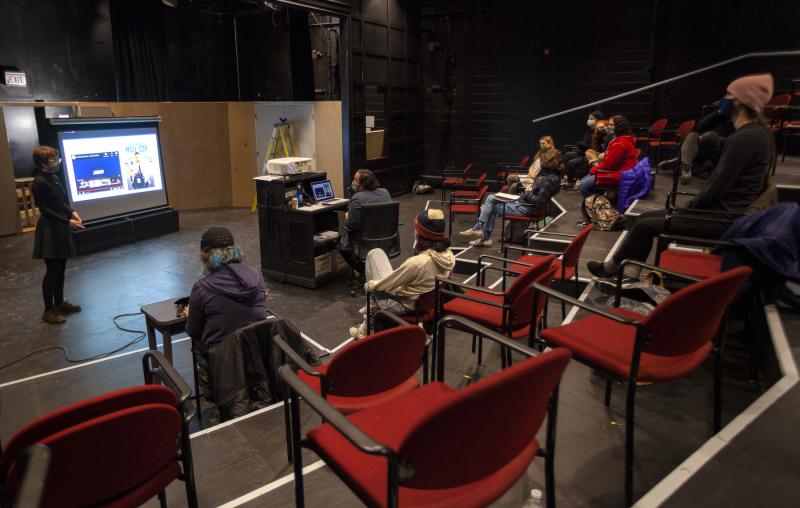 Students giving final presentations during a December Term class taking place in a theatre.