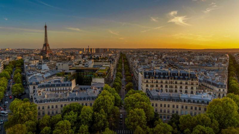 Aerial of Paris France as sun sets with Eiffel Tower in distance