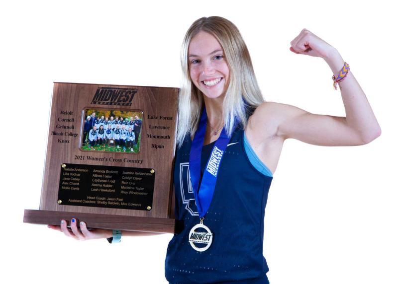 Cristyn Oliver poses with the 2021 Midwest Conference cross country championship trophy.