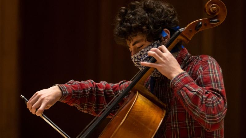 Student playing cello with eyes closed