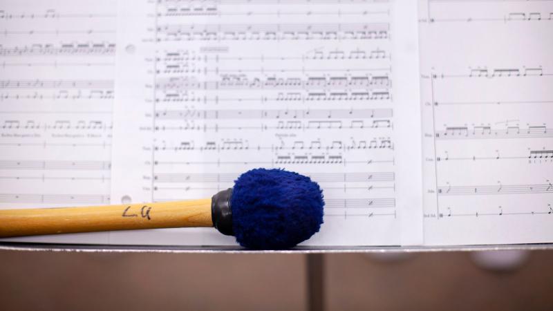 Drumstick in front of sheet music