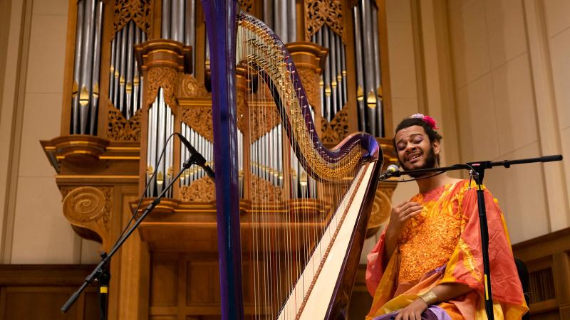 Performer on Memorial Chapel stage with a harp