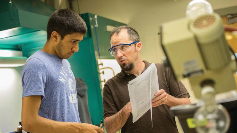 Stefan Debbert works with student in science lab