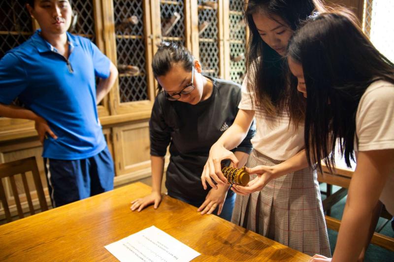 Students work to solve an escape room set up in the Mudd Library during spring term finals. 