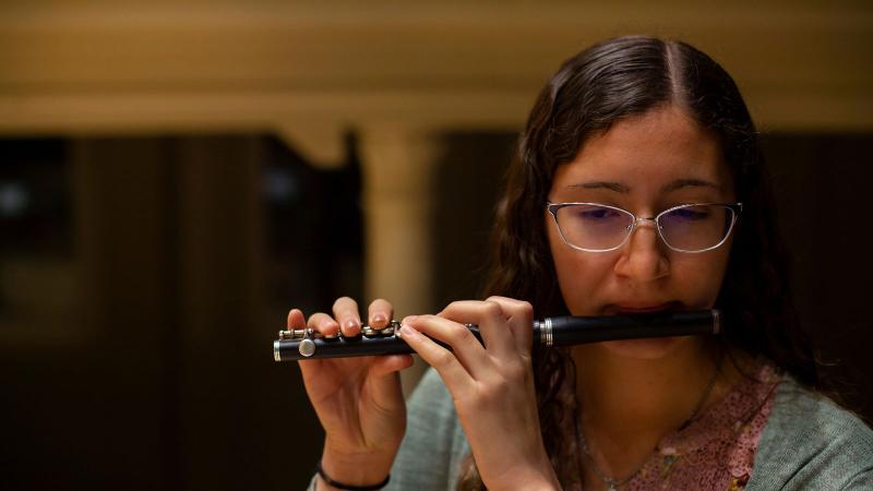 Member of the Flute Ensemble is playing a flute