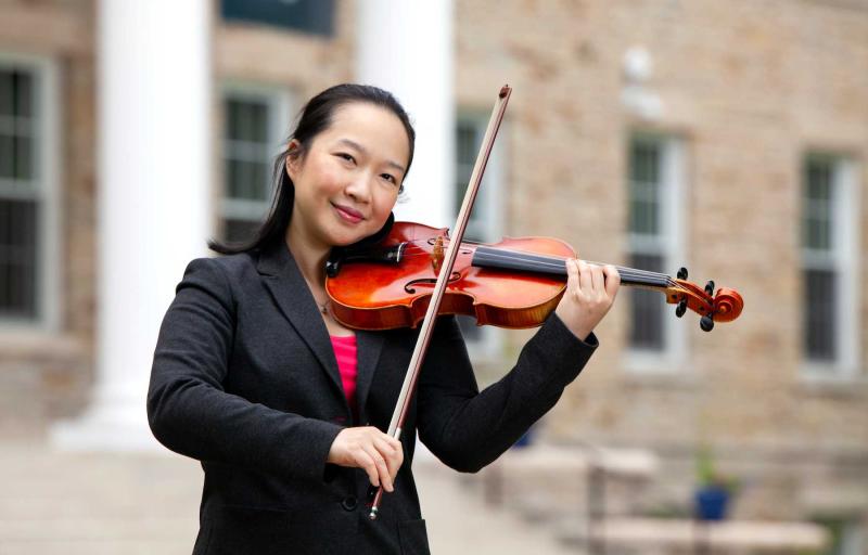 Wen-Lei Gu poses with her violin on Main Hall Green.