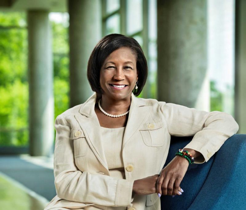 Portrait of President Laurie A. Carter, sitting in front of windows in Warch Center.