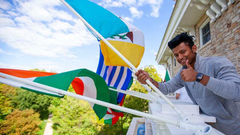 Student holds flag mounted on Main Hall