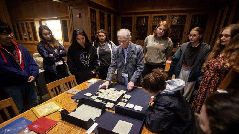 Students gathered around a professor in the Library 