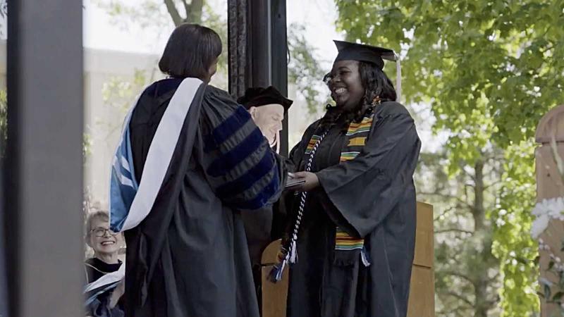 Student accepting diploma from President Carter at 2022 Commencement