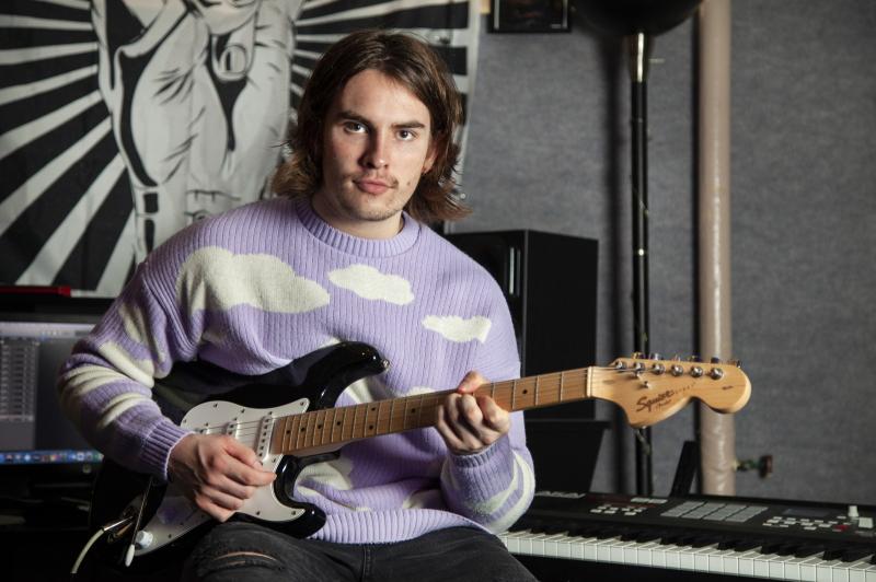 Michael Murphy poses for a photo with his guitar in SOL Studios.