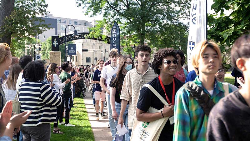 Students walk through arch before President's Welcome