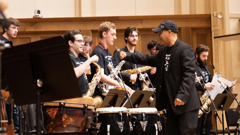 Ensemble director fistbumps saxophone player during Jazz Weekend performance