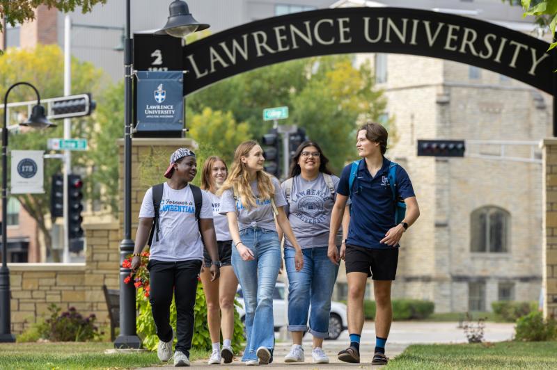 Five Lawrence students walk beneath the Lawrence Arch.