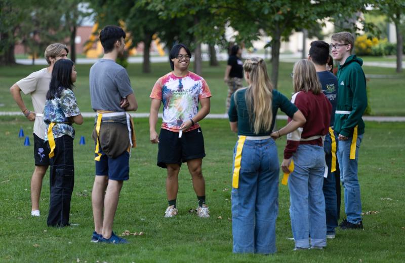 Eight students stand in a semi-circle on Main Hall Green for outdoor games as part of Welcome Week.