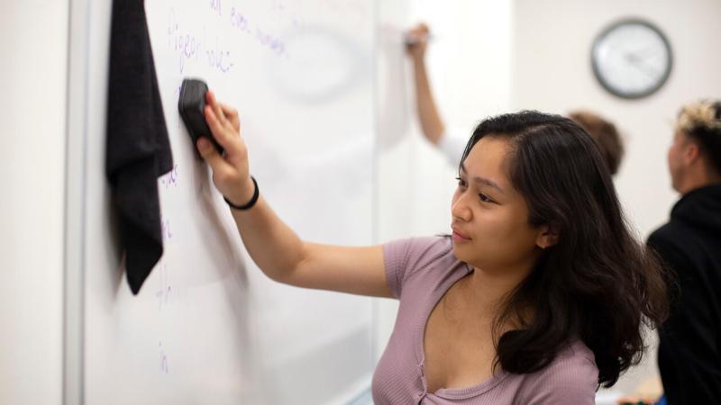 Student at whiteboard erasing