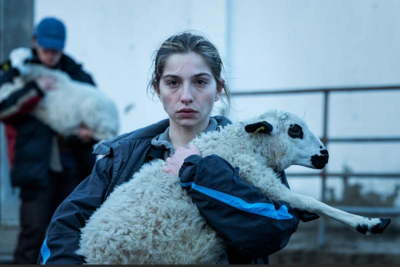 A still from the film As Bestas shows a woman holding a sheep.