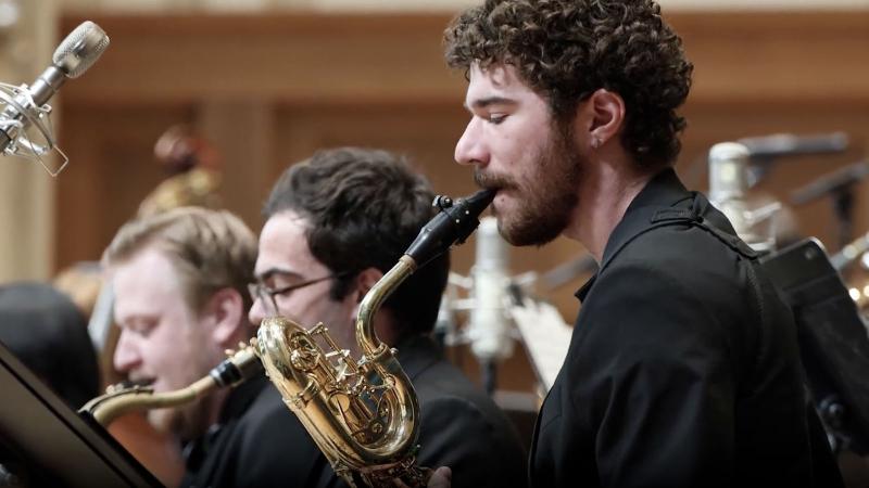 Student playing bass saxophone in Lawrence Memorial Chapel as part of an orchestra performance