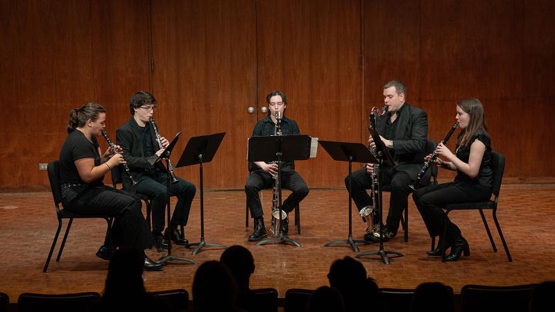 A quintet of clarinetists in performance.