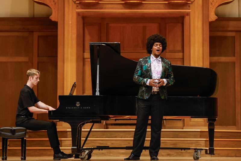A vocalist and pianist in performance on stage.
