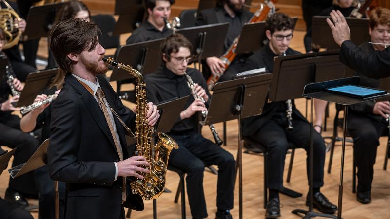 Saxophone soloist performing with wind ensemble.
