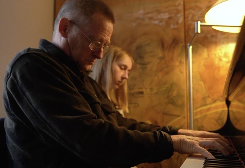 Bill Carrothers playing piano with a student