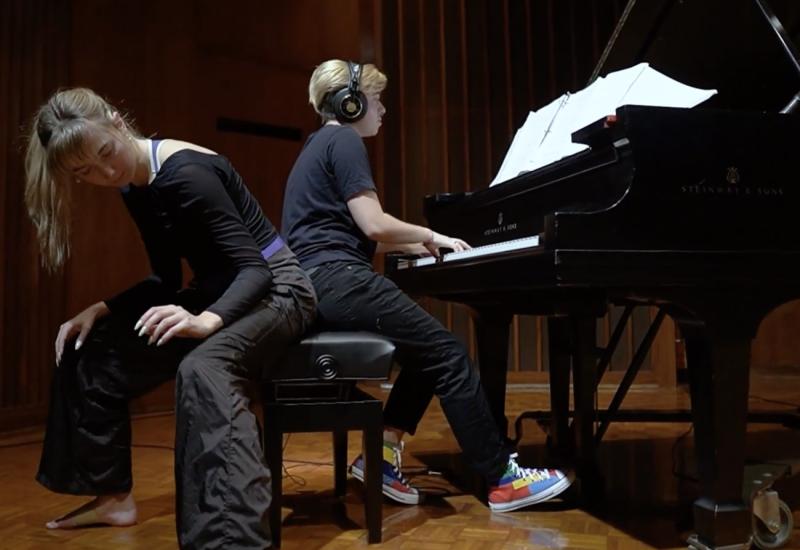 Student playing piano collaborating with an expressive student dancer