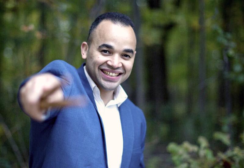 Jean Carlo Ureña Gonzalez standing in woods and pointing at viewer with drum sticks