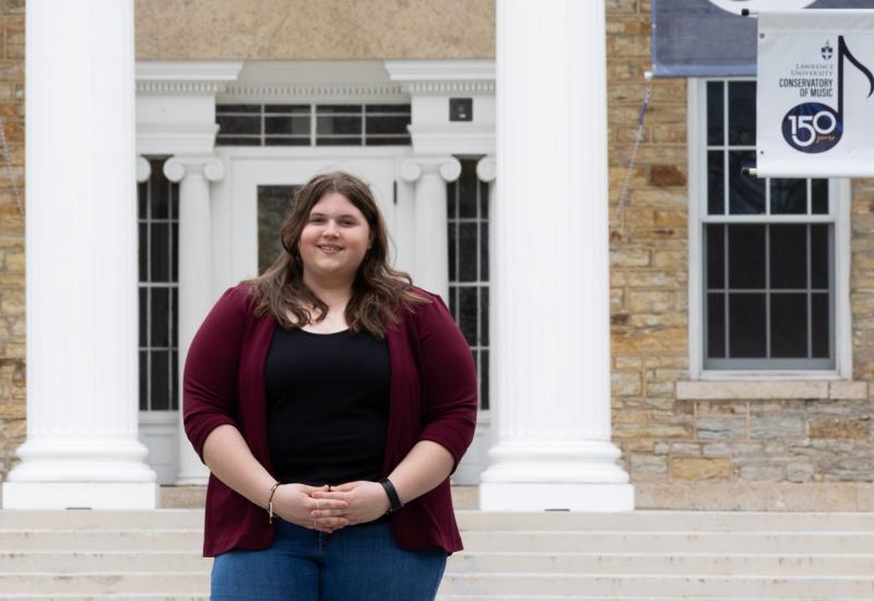 Brooklyn Schara poses for a photo in front of Main Hall.