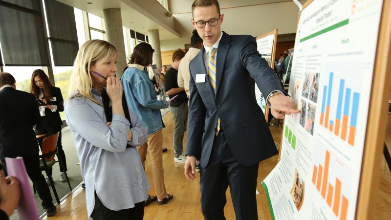 student shows work to faculty during Biofest