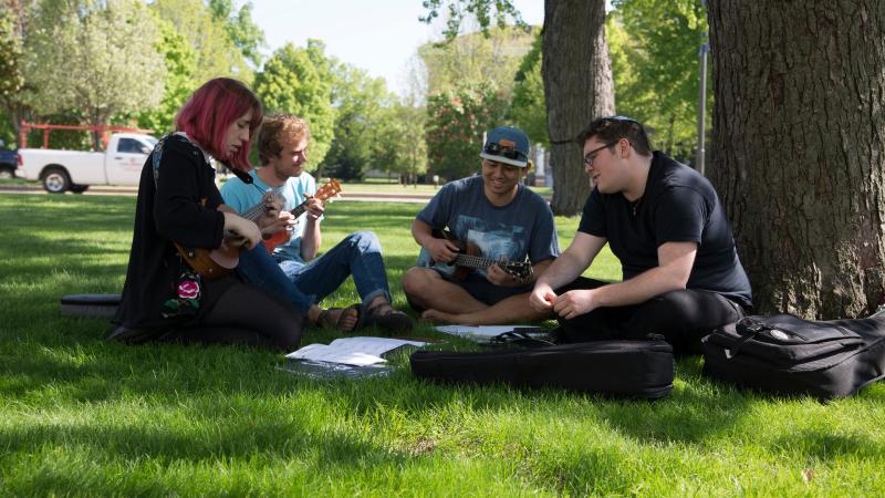 students play music together on lawn by Conservatory of Music