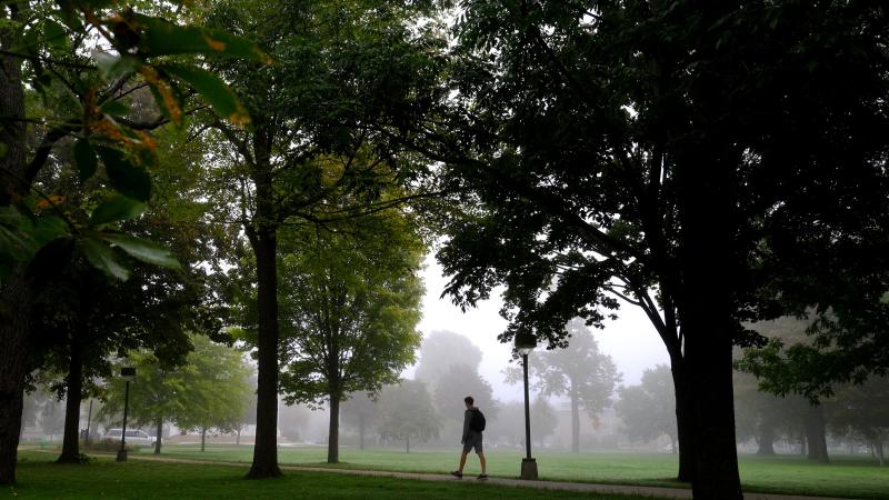 student on campus surrounded with fog