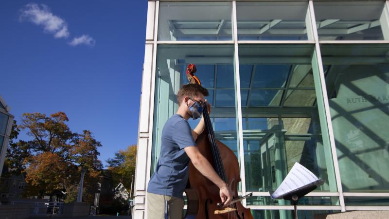 David Pickar '23, a percussion major, practices the upright bass for a methods class on the steps of the Shattuck Hall of Music