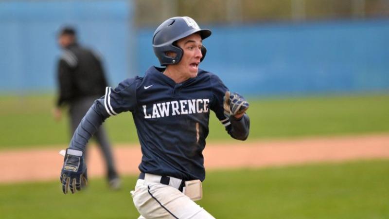 Clayton Agler, wearing a Lawrence baseball uniform, runs toward a base.