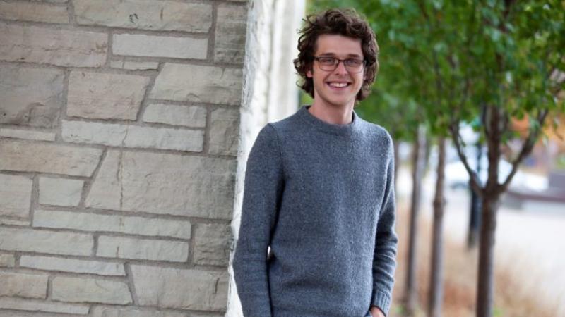 Jonathan Hogan, wearing a grey sweater, smiles at the camera.