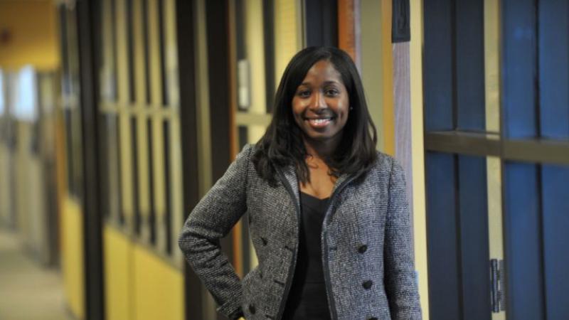 Andrea Lewis Hartung, wearing a grey blazer, smiles at the camera.