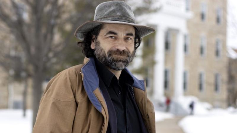 Jake Frederick, wearing a grey, rimmed hat, stands on a snow-covered Main Hall Green.