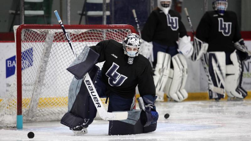 The goalie of women's Hockey Team preventing the hockey puck from entering the net