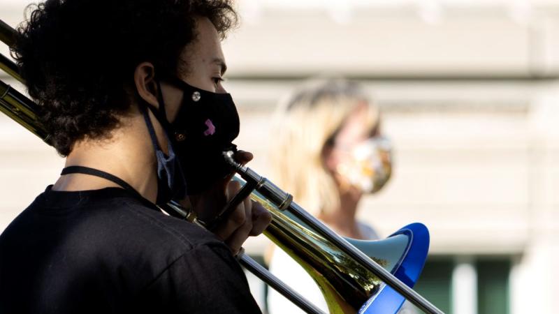 Matvei Mozhaev playing the trombone outside 