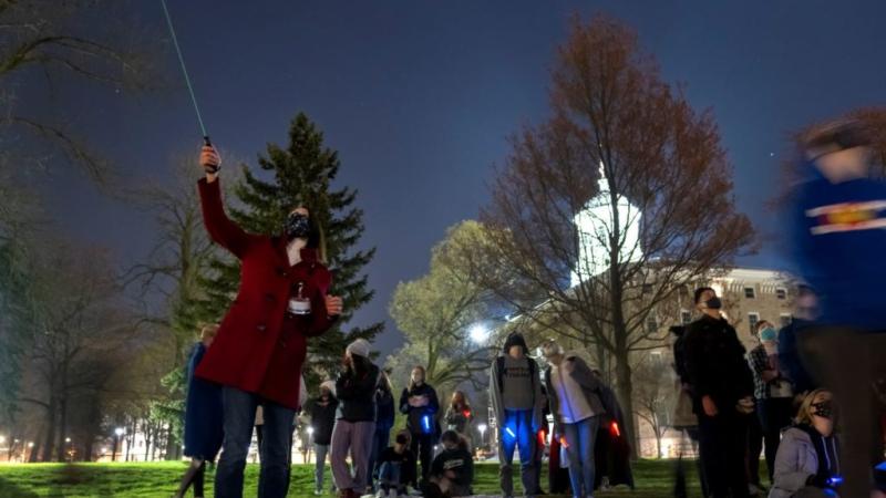 Professor Pickett showing her student the stars at night outside of Main Hall