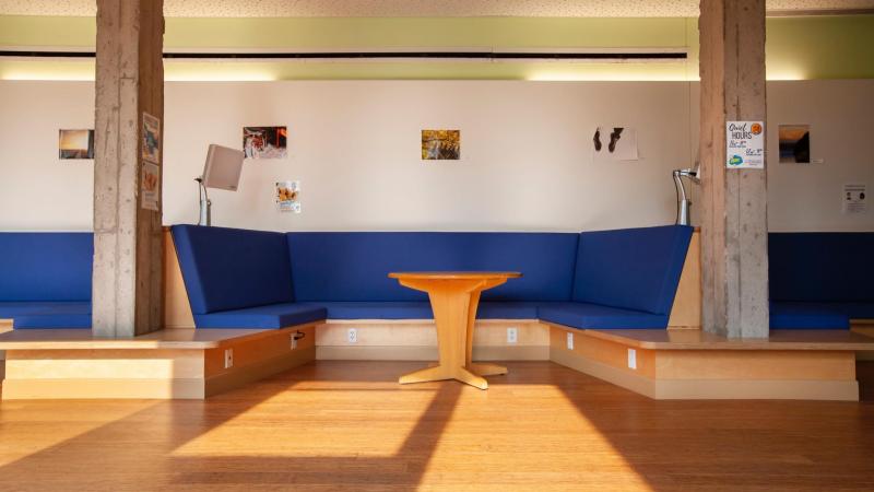 low modern booth with blue cushions around a wooden table 
