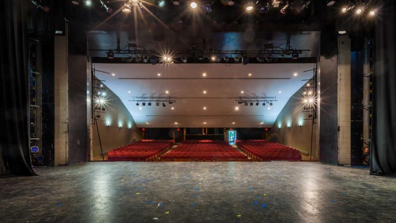 Empty stage facing red audience seats