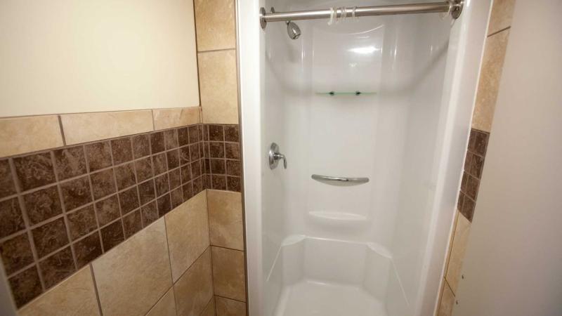 Tiled wall leading to standing shower 