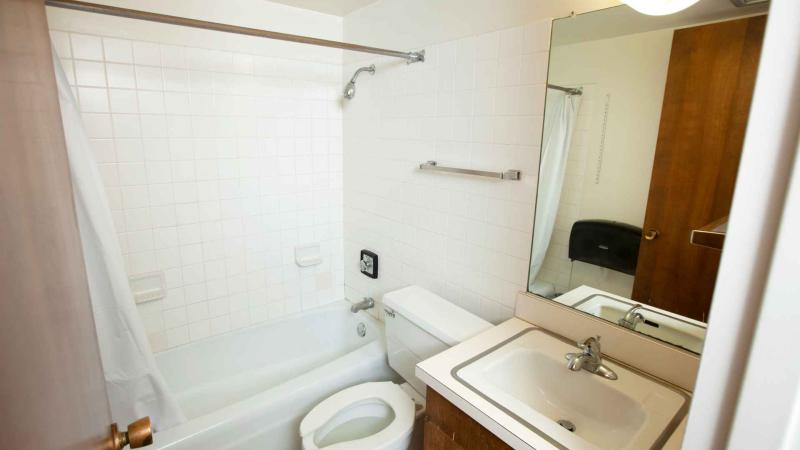 Tiled bathroom with shower and bathtub, toilet and mirror over a sink