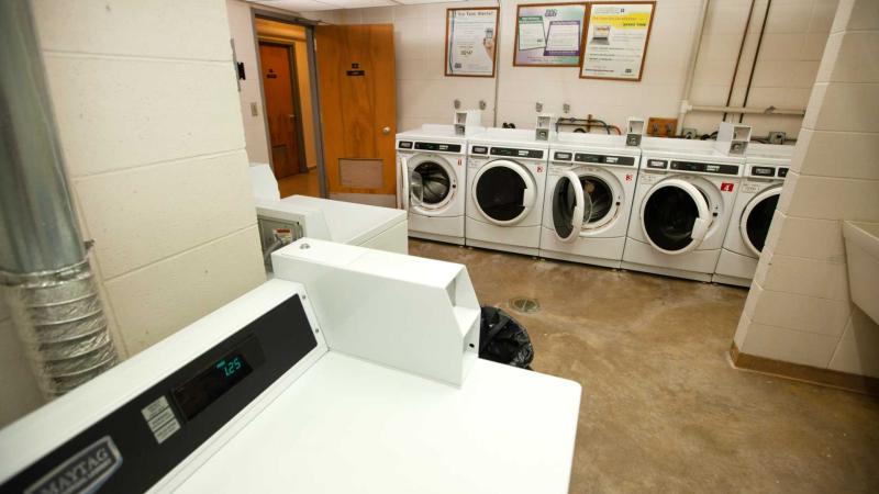 Large room with several washing machines and dryers
