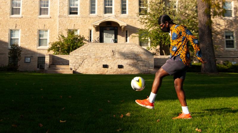Student is playing soccer outdoors.