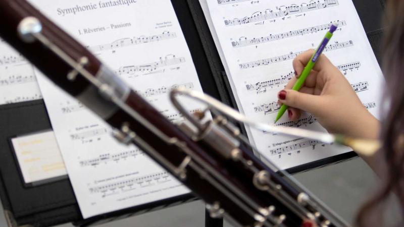 Student writing on sheet music during Viking Bassoon Ensemble rehearsals.