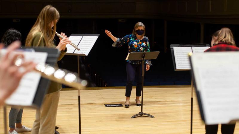 Erin Lesser, associate professor of flute, conducting students while they play during Flute Ensemble rehearsals.
